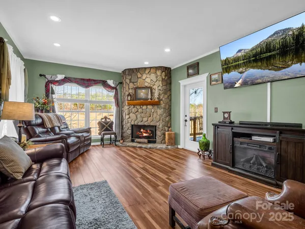 a living room with furniture a fireplace and a flat screen tv