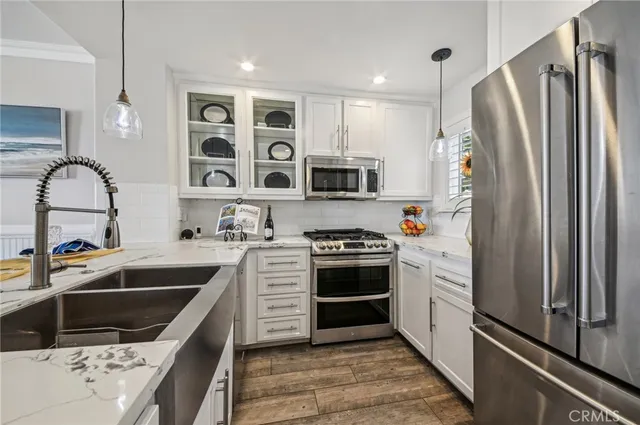 a kitchen with stainless steel appliances a refrigerator sink and white cabinets