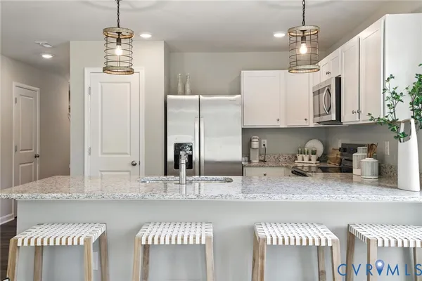 a kitchen with stainless steel appliances granite countertop a sink a stove and a refrigerator