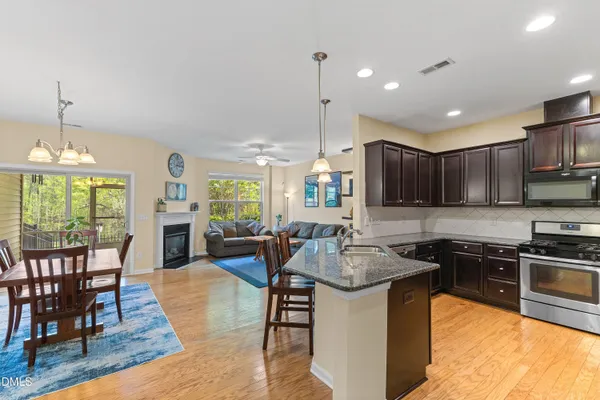 a kitchen with sink stove dining table and chairs