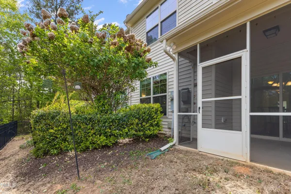a view of backyard with potted plants and wooden fence