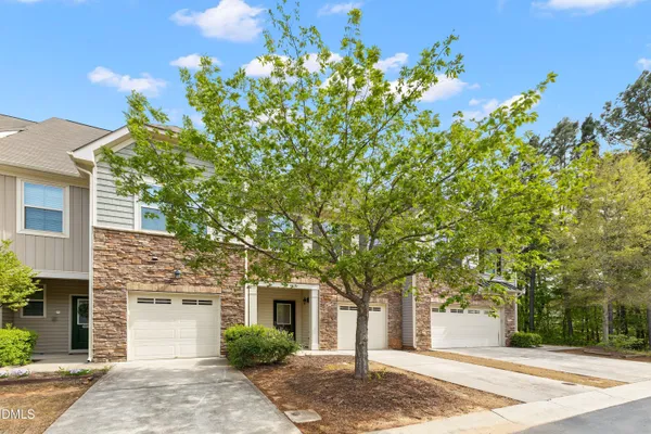 a front view of a house with a tree