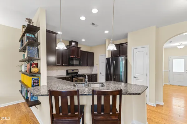 a kitchen with stainless steel appliances kitchen island granite countertop a sink and cabinets