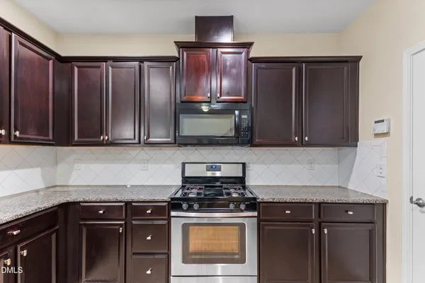 a kitchen with granite countertop wood cabinets and stainless steel appliances