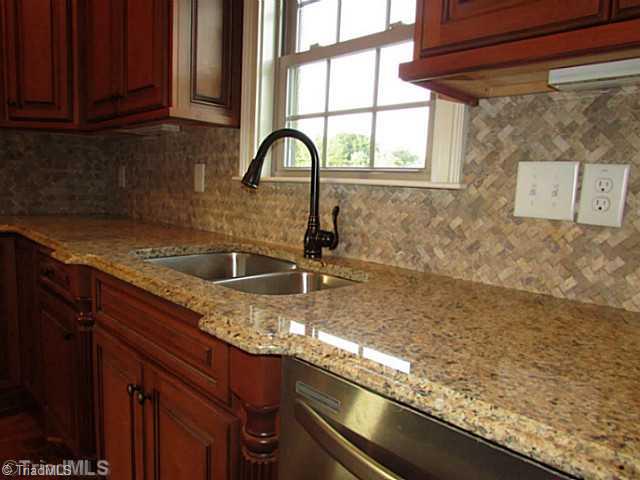6303 Rylan Court Browns Summit, NC 27214 - Photo 10 of 14 Other. Kitchen details: granite counter, stainless steel appliances, spacious quality cabinets, tile backsplash, center island, and more!