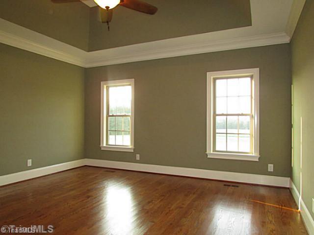Master Bedroom. The master bedroom is located on the main floor and has a tray ceiling with gleaming hardwoods.