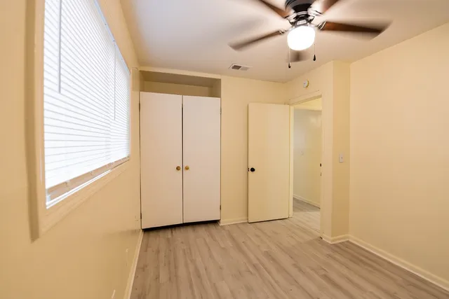 a view of a hallway with wooden floor and closet