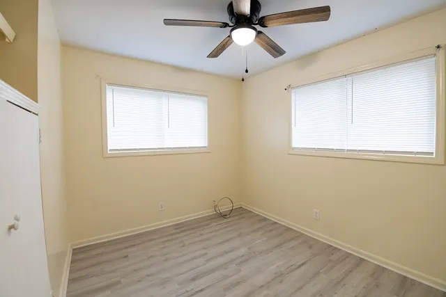 an empty room with a window and a fan