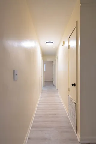 a view of a hallway with wooden floor