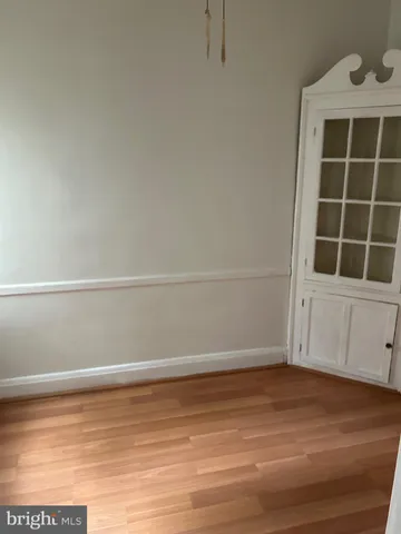 a view of an empty room with wooden floor and windows