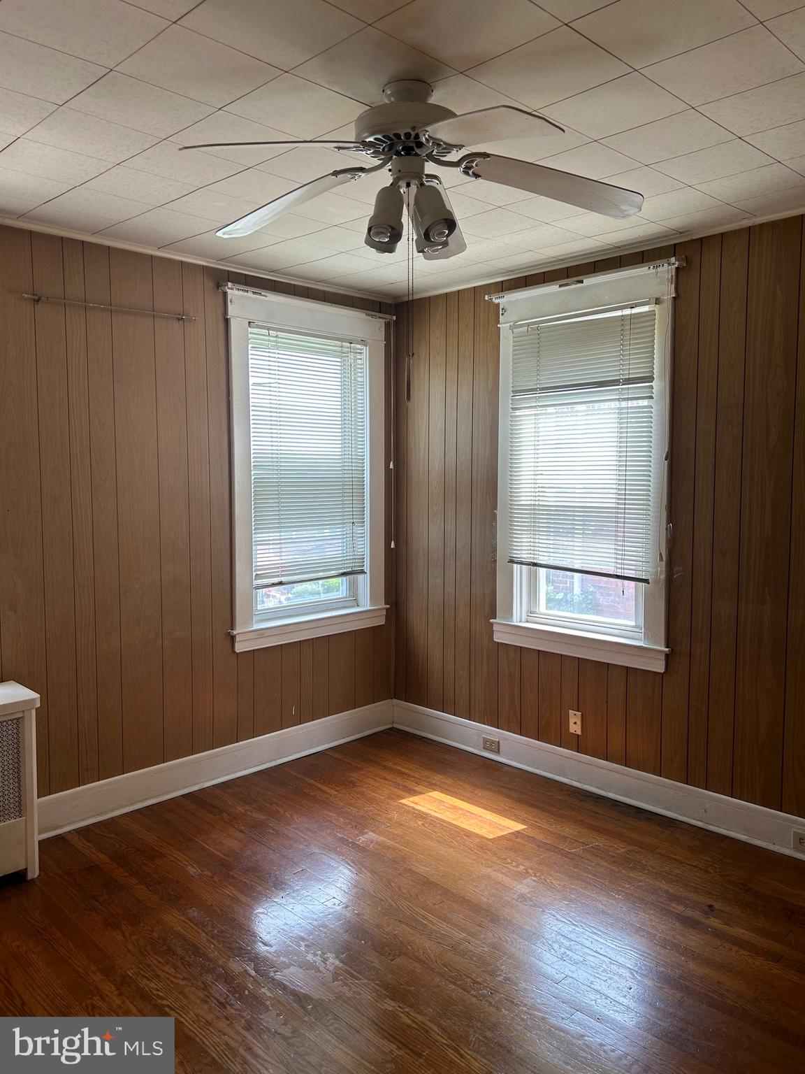 3216 Burleith Avenue Baltimore, MD 21215 - Photo 9 of 14 an empty room with wooden floor and windows