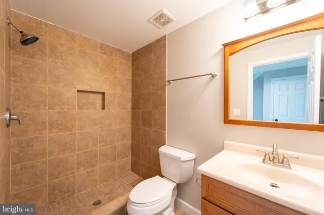 a bathroom with a sink mirror toilet and shower