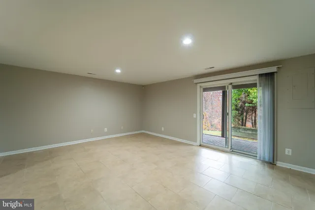 an empty room with sliding glass door and mountain view