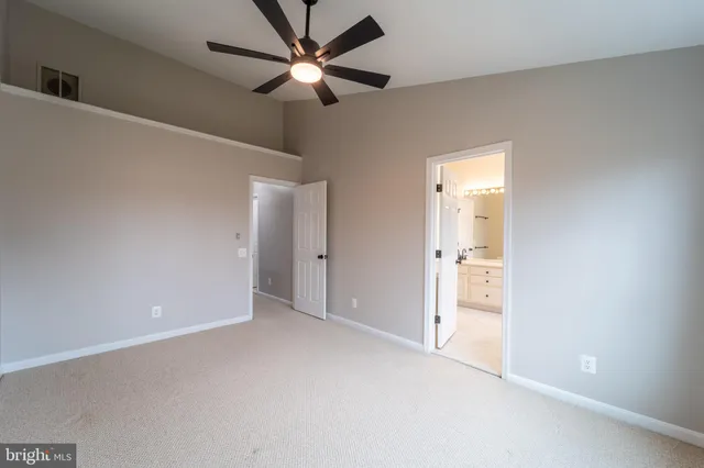 an empty room with chandelier fan