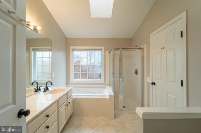 a spacious bathroom with a tub sink shower and mirror