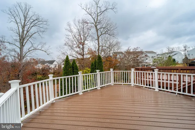 a view of balcony with wooden floor and fence and trees