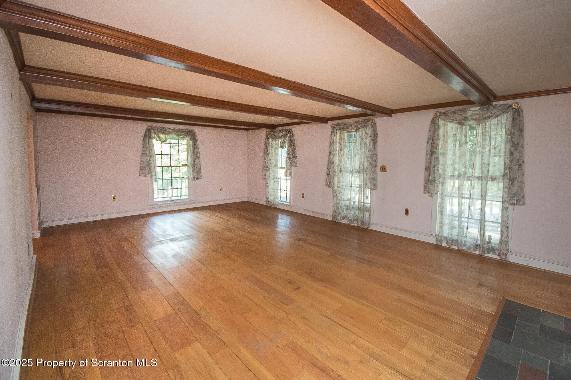 612 Clinton Street Waverly, PA 18471 - Photo 18 of 44 a view of an empty room with a window and wooden floor