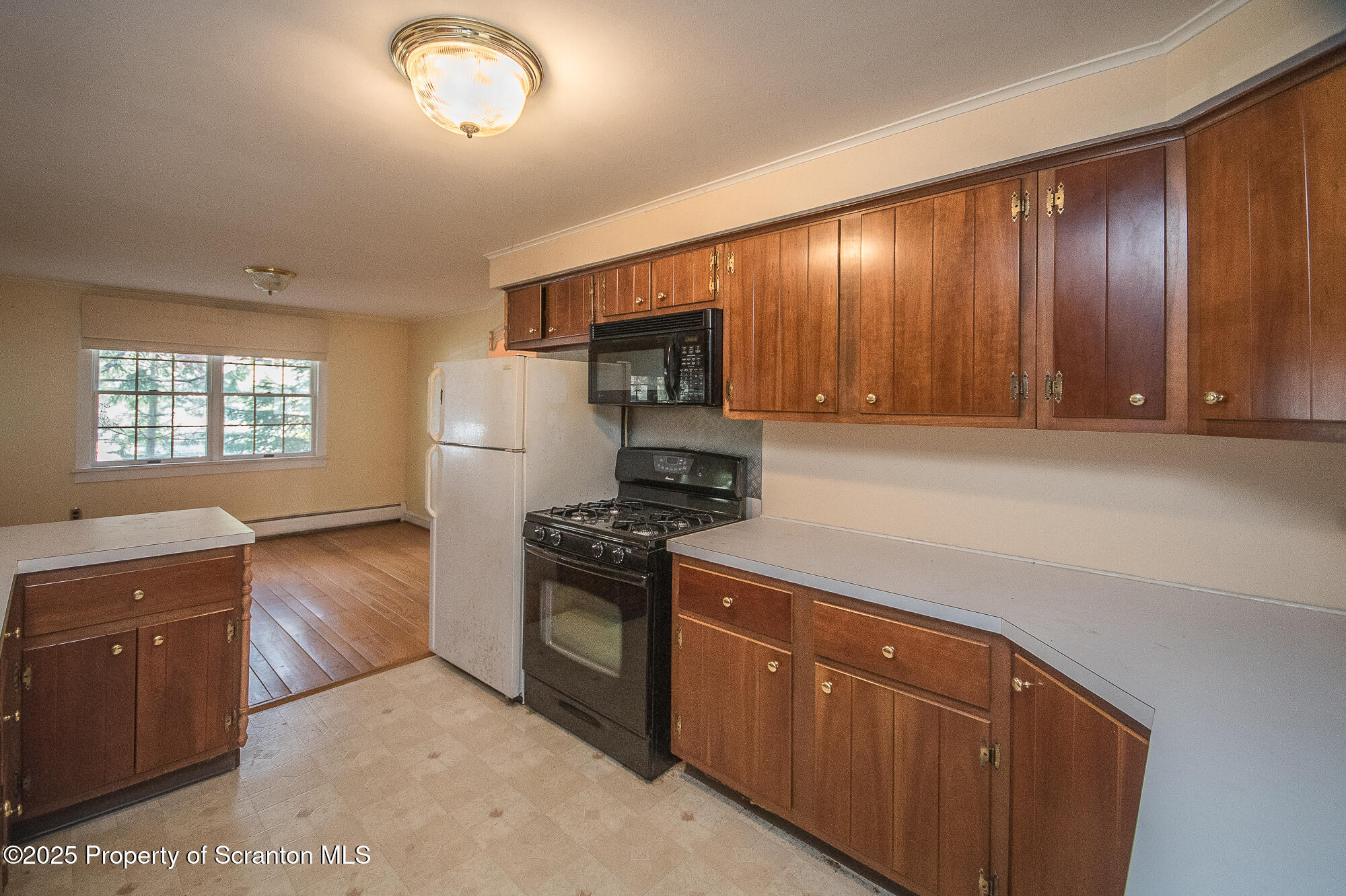 612 Clinton Street Waverly, PA 18471 - Photo 22 of 44 a kitchen with granite countertop wooden cabinets and white appliances
