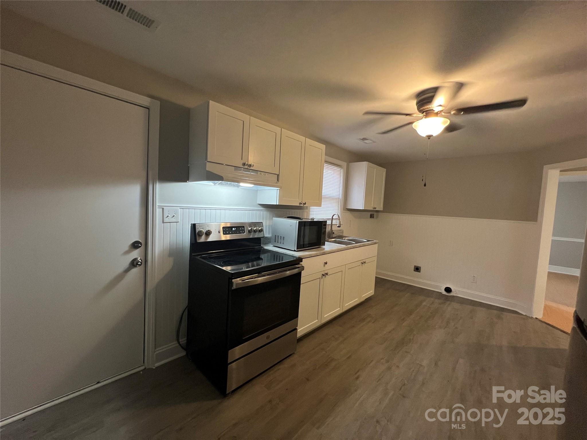 3113 Tuckaseegee Road Charlotte, NC 28208 - Photo 12 of 12 a kitchen with granite countertop a stove cabinets and wooden floor