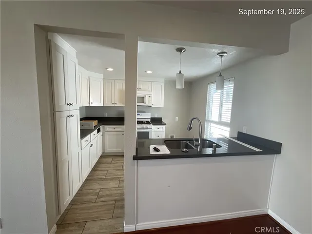 a kitchen with white cabinets and appliances