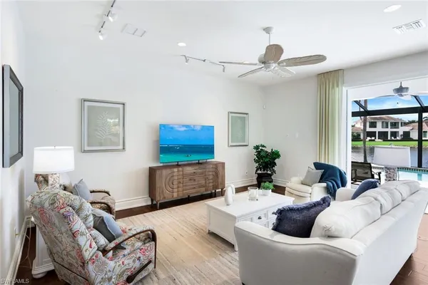 a kitchen with a refrigerator a sink dishwasher and white cabinets with wooden floor
