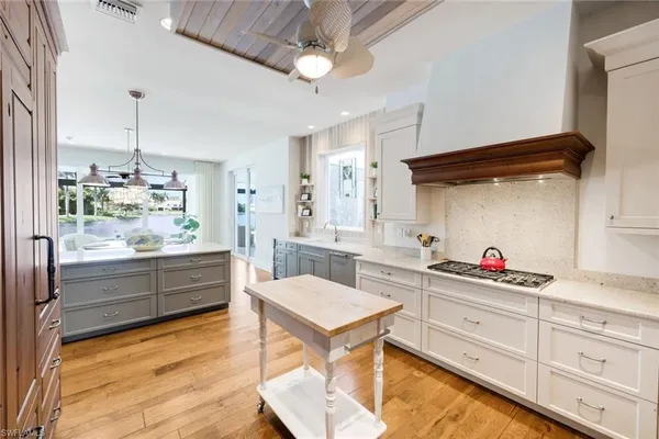a dining hall with stainless steel appliances granite countertop a coffee maker a sink and a refrigerator
