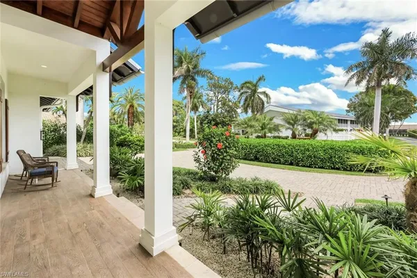 a view of a porch with chairs and potted plants