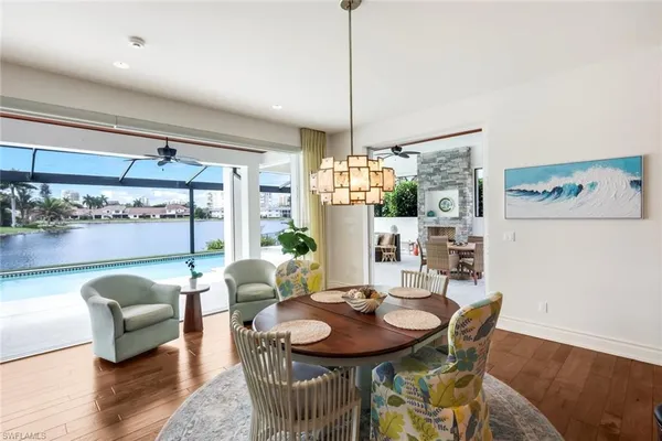 a dining room with furniture a chandelier and wooden floor