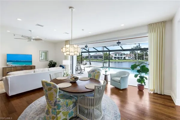 a dining room with furniture a chandelier and wooden floor