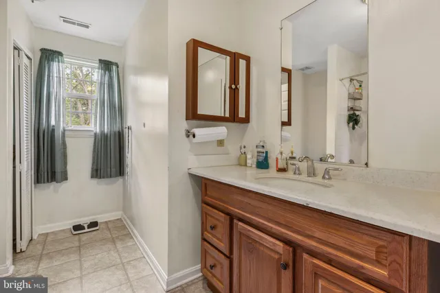 a bathroom with a granite countertop sink and a mirror