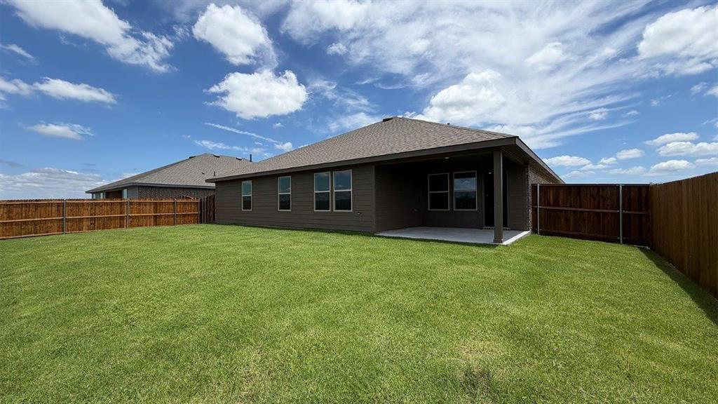 2003 Reveille Way Terrell, TX 75160 - Photo 22 of 25 Expansive backyard featuring a manicured lawn, full privacy fencing, and a covered concrete patio