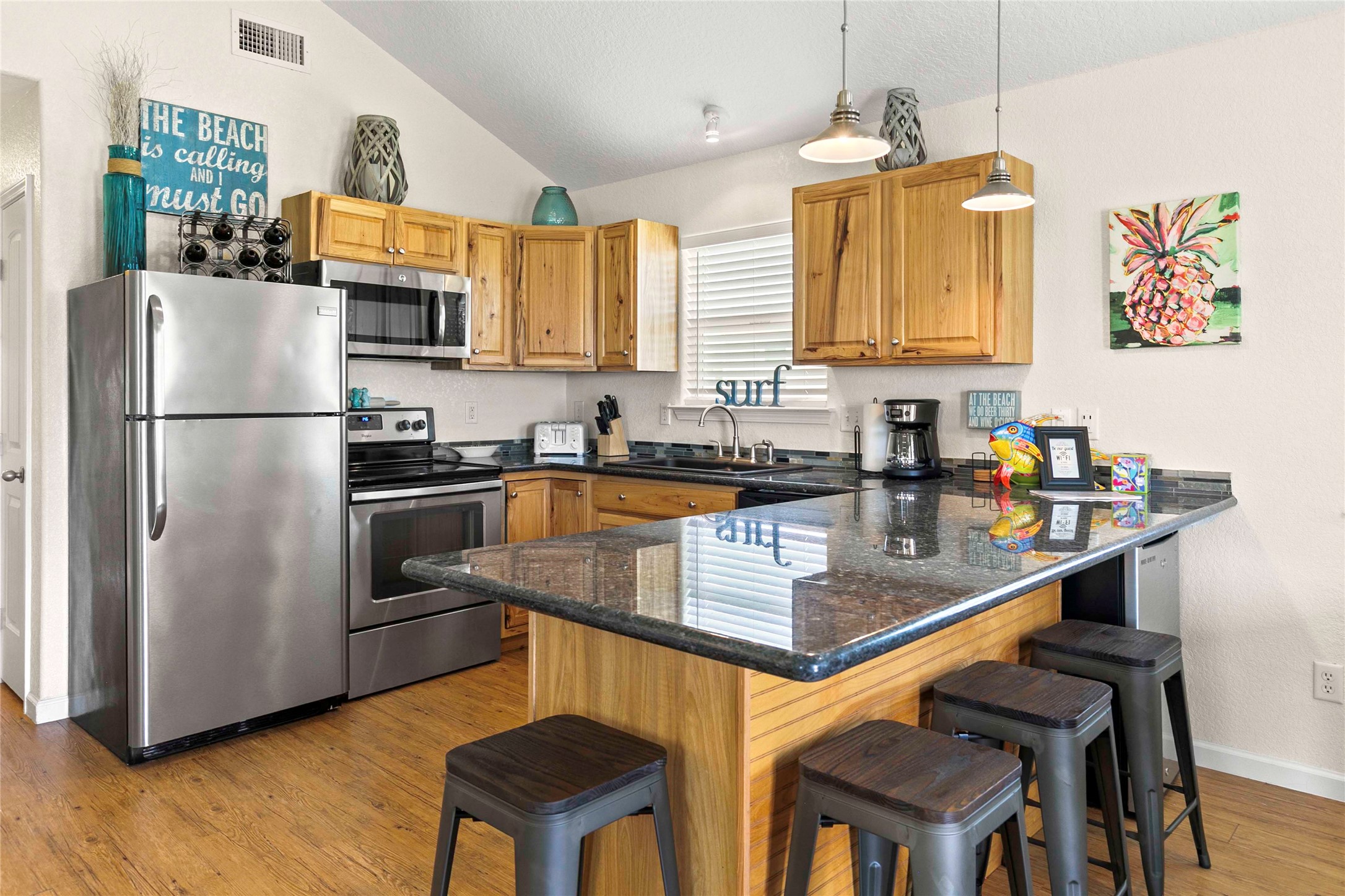 757 Bluewater Highway Surfside Beach, TX 77541 - Photo 16 of 44 a kitchen with stainless steel appliances white cabinets a sink a stove a refrigerator and island with wooden floor