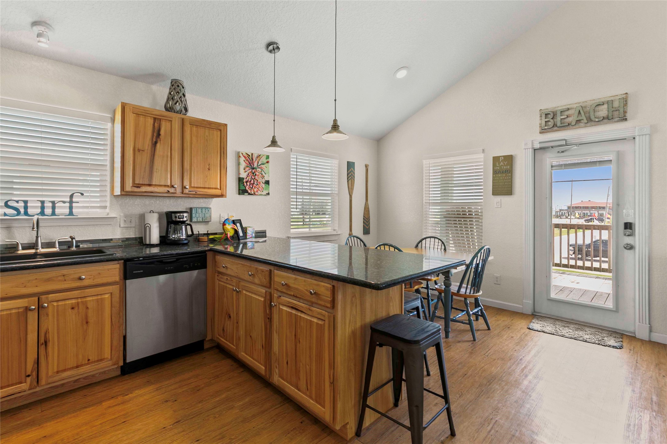 757 Bluewater Highway Surfside Beach, TX 77541 - Photo 18 of 44 a kitchen with stainless steel appliances granite countertop a kitchen island a table and chairs in it