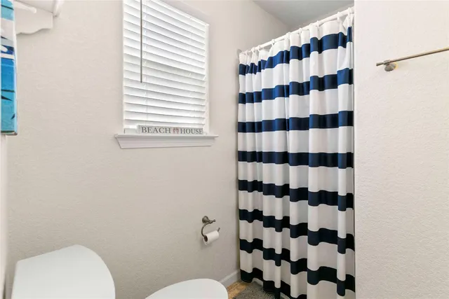 a bathroom with a sink a toilet a shower and a mirror