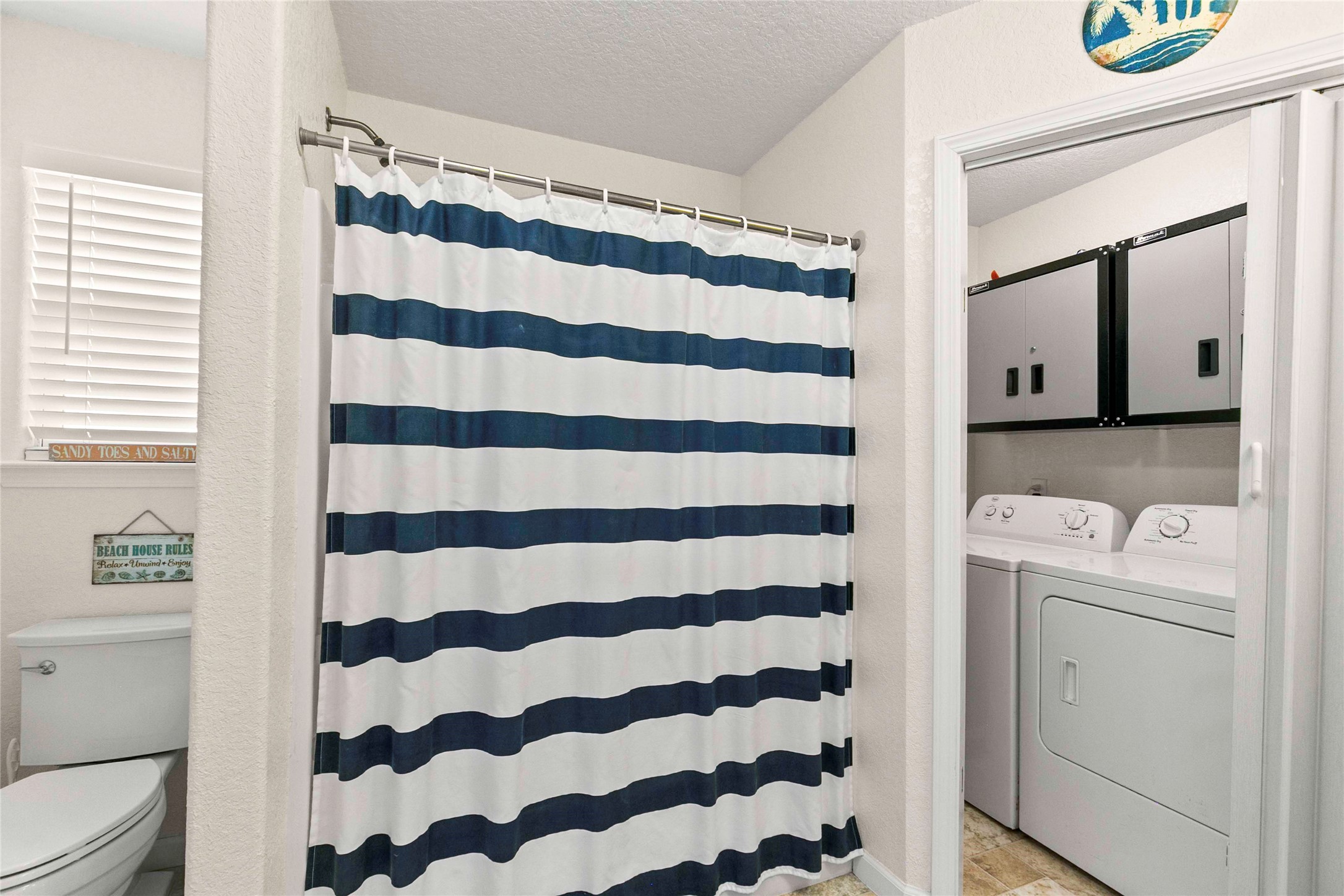 757 Bluewater Highway Surfside Beach, TX 77541 - Photo 29 of 44 a bathroom with a toilet and a shower curtain