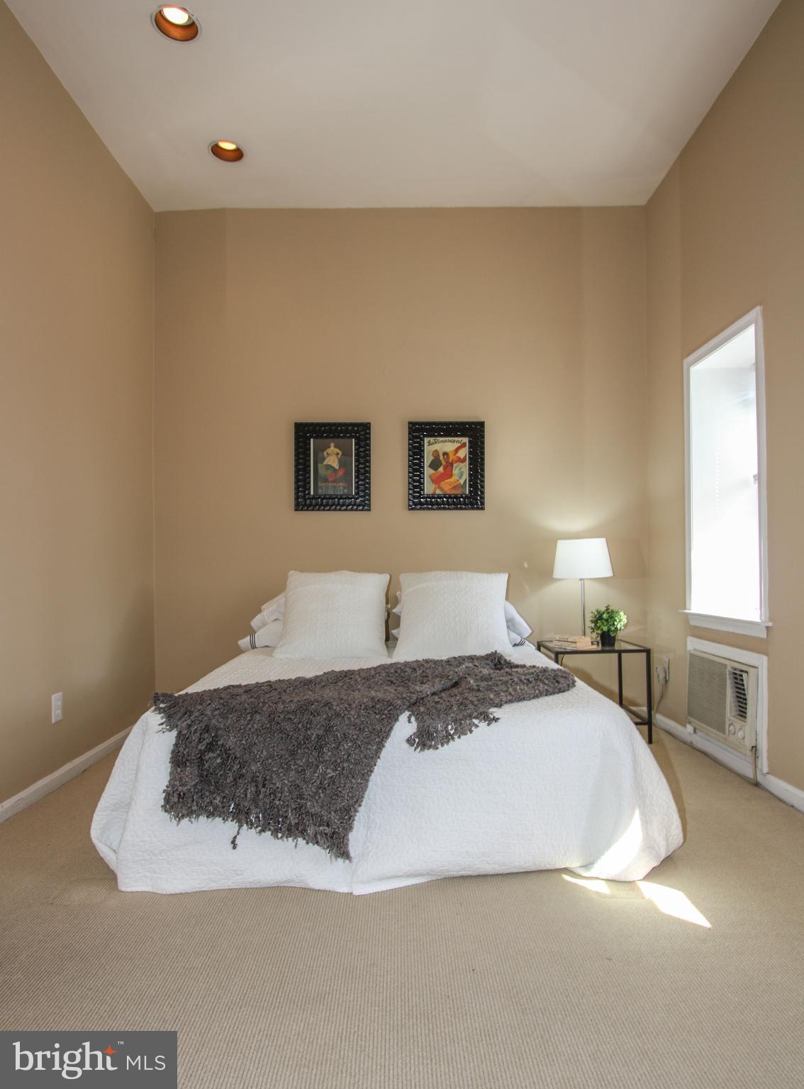 1434 Potomac Avenue Southeast, Unit 5 Washington, DC 20003 - Photo 24 of 38 a spacious bedroom with a bed and a couch