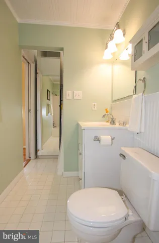 a white toilet sitting next to a bathroom sink and a mirror