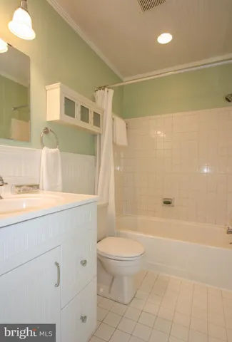 a bathroom with a bathtub shower sink vanity and toilet