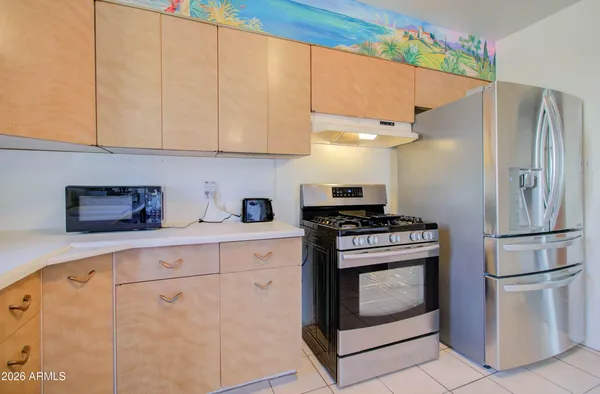 a kitchen with stainless steel appliances granite countertop a refrigerator sink and stove