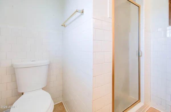 a white toilet sitting next to a shower