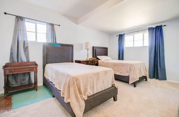 a spacious bedroom with two beds and a window