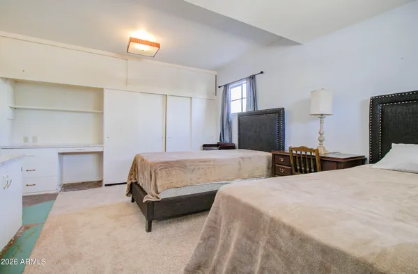 a bedroom with two beds and a lamp