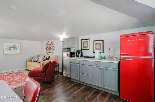 a living room with furniture and a refrigerator