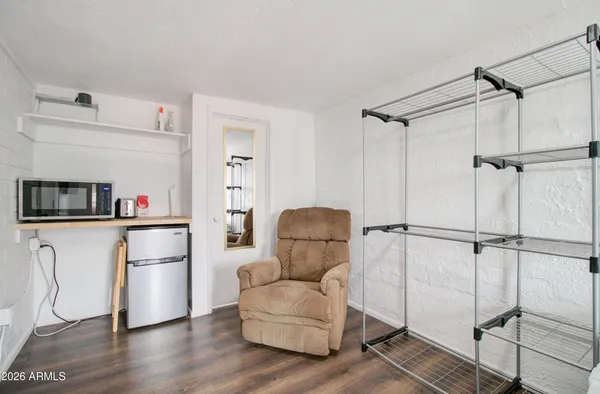 a living room with furniture and a refrigerator