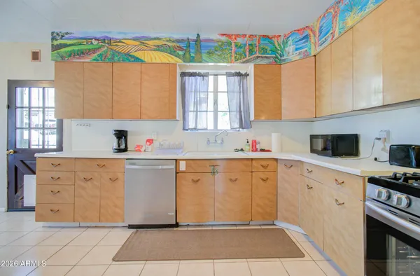 a kitchen with stainless steel appliances a stove a sink a microwave a refrigerator and cabinets