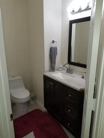 a bathroom with a sink vanity and a toilet