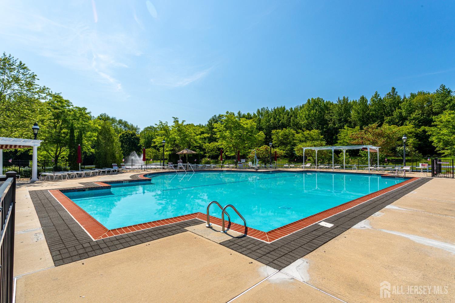40 Azalea Drive Old Bridge, NJ 08857 - Photo 31 of 35 a view of a pool with a bench and trees in the background
