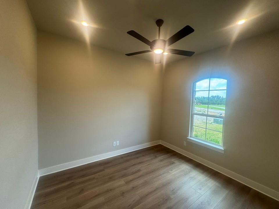 412 Indian Crk Road Van Alstyne, TX 75495 - Photo 6 of 24 an empty room with wooden floor and windows