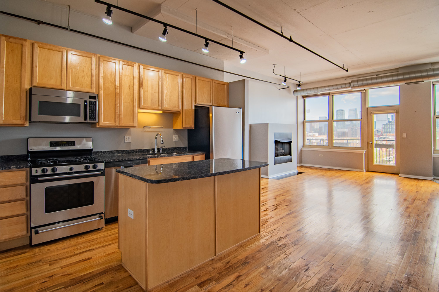 6 South Laflin Street, Unit 808 Chicago, IL 60607 - Photo 2 of 13 a kitchen with stainless steel appliances granite countertop a stove top oven a sink dishwasher a refrigerator and a microwave