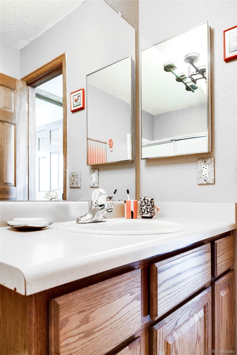 6549 Poppy Street Arvada, CO 80007 - Photo 23 of 33 a bathroom with a sink and a mirror
